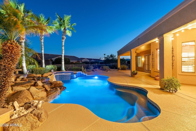 view of pool featuring a pool with connected hot tub, a patio area, fence, and french doors