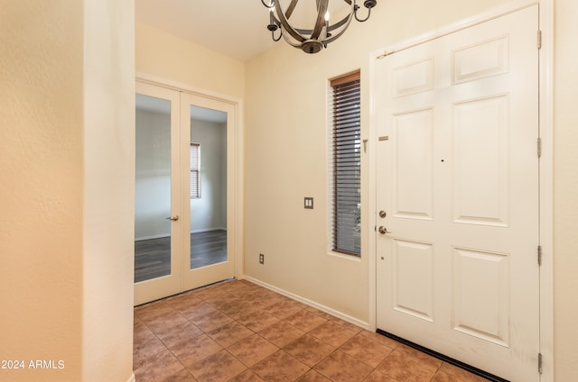 foyer featuring light hardwood / wood-style flooring, french doors, and a notable chandelier