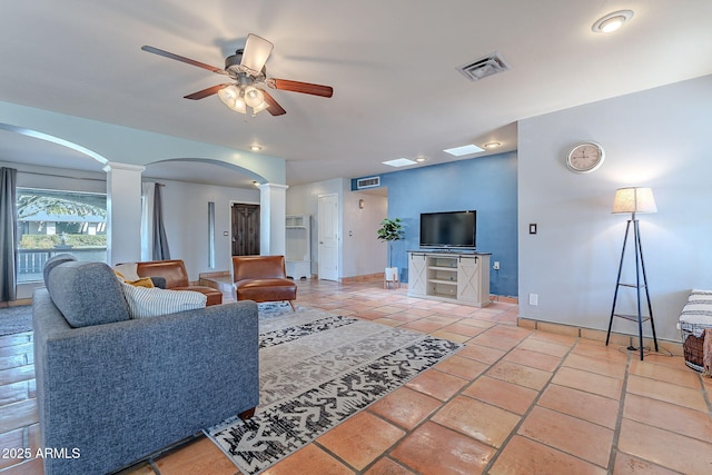 living room featuring decorative columns, tile patterned flooring, and ceiling fan