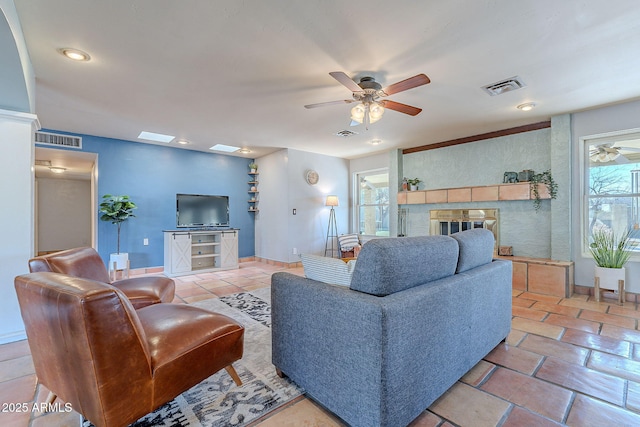 living room featuring ceiling fan and a healthy amount of sunlight