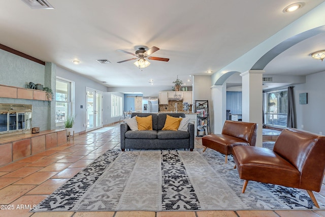 living room with ceiling fan and ornate columns