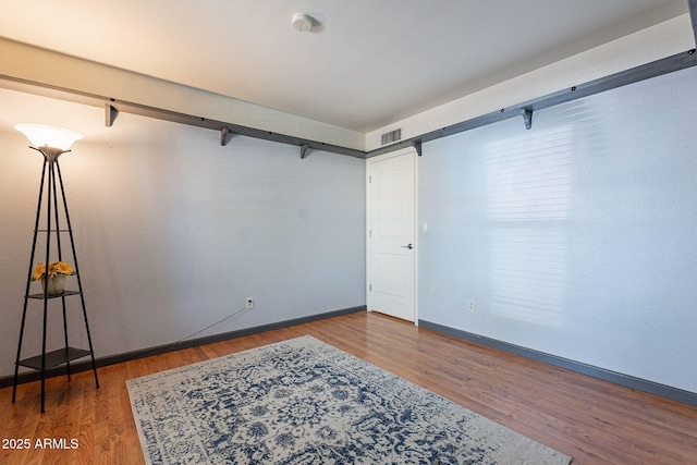 empty room with wood-type flooring and a barn door