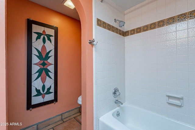 bathroom featuring toilet and tiled shower / bath combo