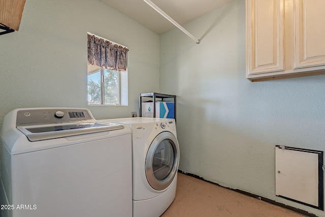 clothes washing area with cabinets and washing machine and dryer