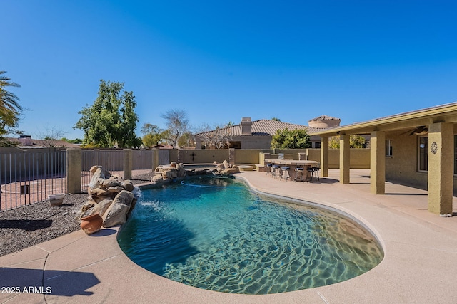 view of pool with a patio area, pool water feature, and an in ground hot tub