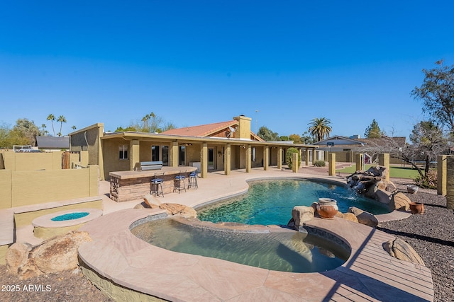 view of swimming pool with a bar, area for grilling, an in ground hot tub, a pergola, and a patio area