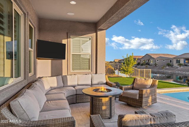 view of patio with an outdoor living space with a fire pit