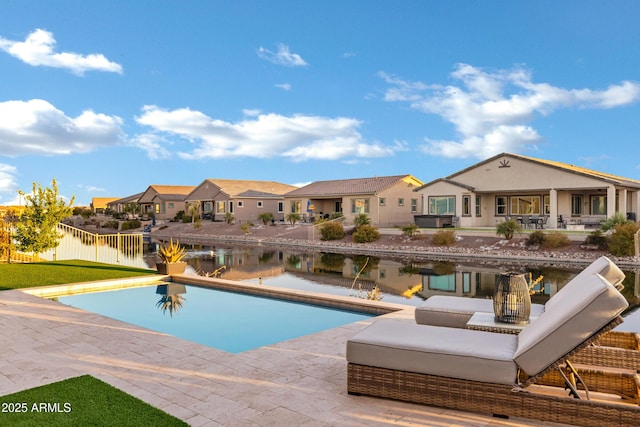 view of pool featuring a patio and a water view