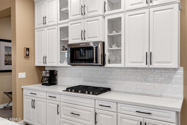 kitchen with white cabinetry, appliances with stainless steel finishes, and backsplash