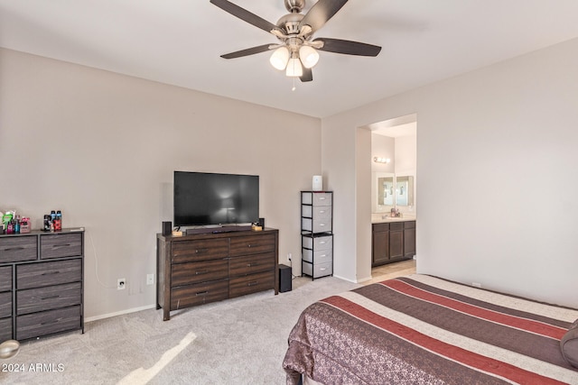 carpeted bedroom with ensuite bath and ceiling fan