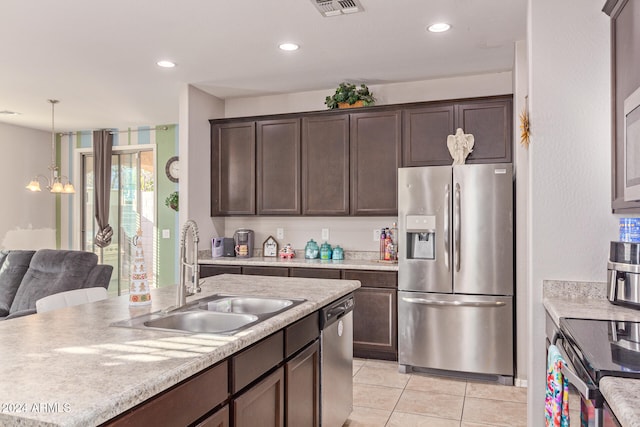 kitchen featuring sink, dark brown cabinetry, stainless steel appliances, and hanging light fixtures