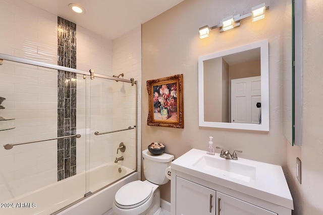 full bathroom featuring vanity, bath / shower combo with glass door, and toilet