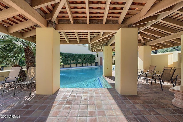 view of swimming pool with pool water feature and a patio area