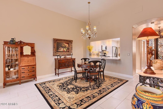 tiled dining room featuring a high ceiling and an inviting chandelier