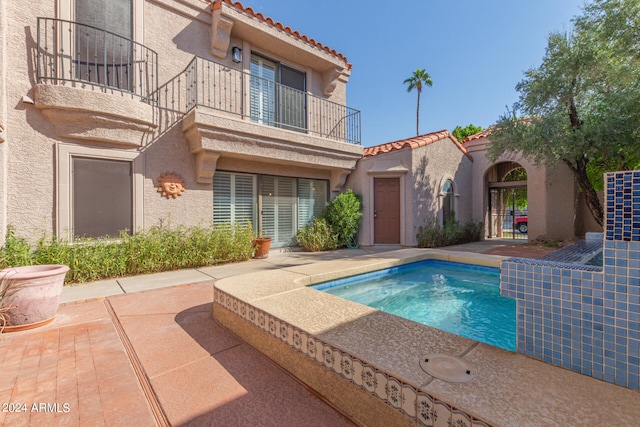 rear view of house with a balcony and a patio area