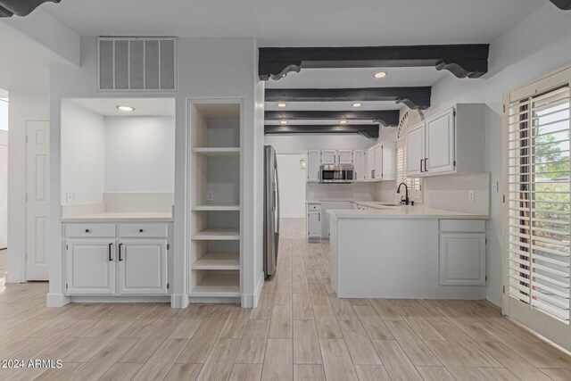 kitchen featuring appliances with stainless steel finishes, sink, light hardwood / wood-style flooring, and white cabinets