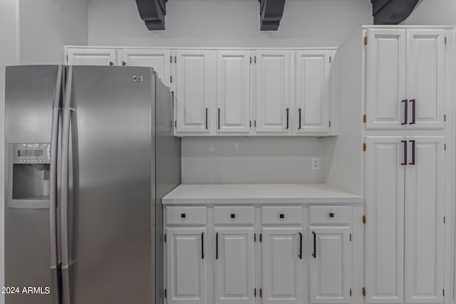 kitchen with stainless steel fridge with ice dispenser and white cabinetry