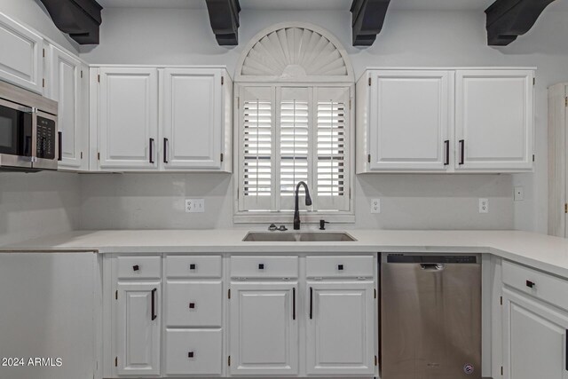 kitchen with white cabinets, appliances with stainless steel finishes, and sink