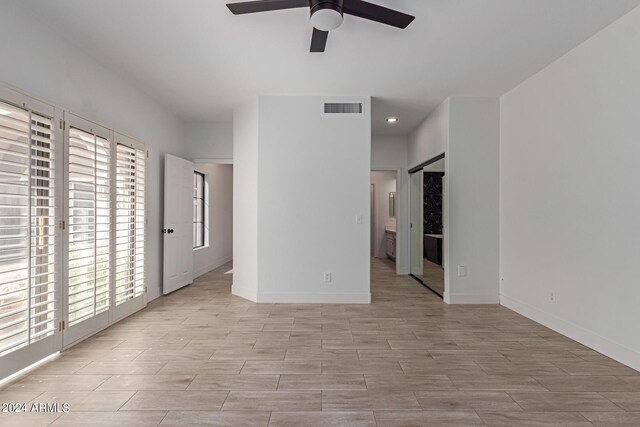 spare room featuring ceiling fan and plenty of natural light