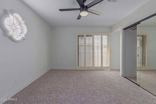 unfurnished bedroom with ceiling fan, a closet, and carpet flooring