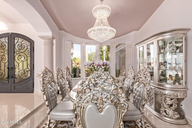 dining area with decorative columns, french doors, and a notable chandelier