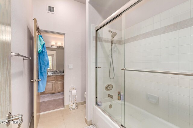 full bathroom featuring tile patterned floors, vanity, toilet, and shower / bath combination with glass door