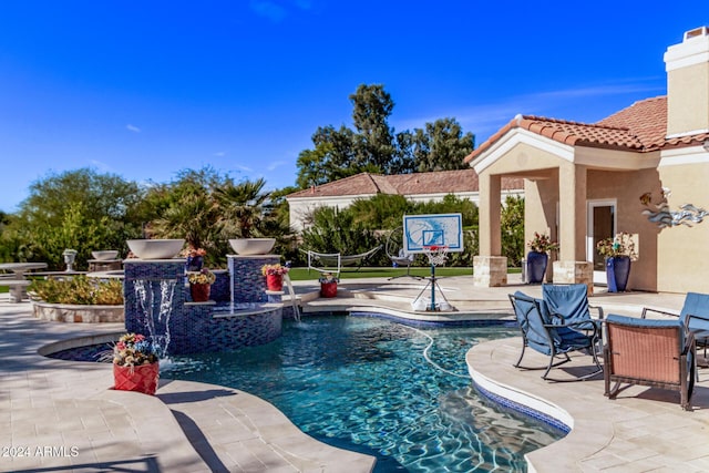 view of pool with pool water feature and a patio area