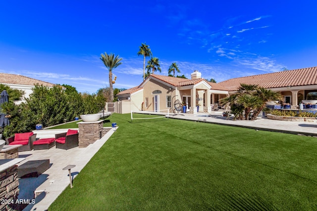 back of property with outdoor lounge area, a yard, and a patio