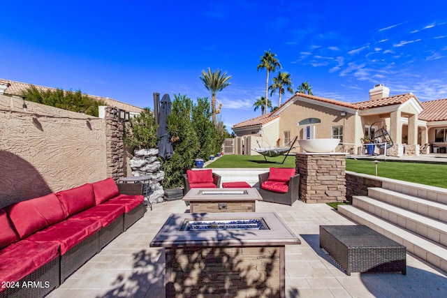 view of patio with an outdoor living space with a fire pit