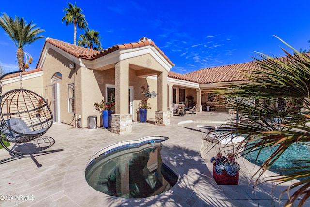 back of property with a patio and a hot tub