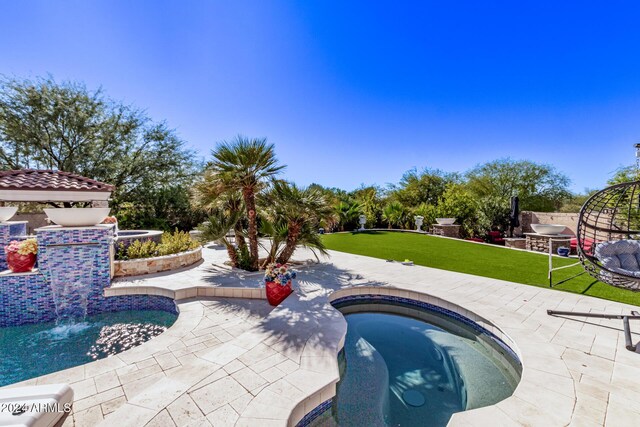 view of swimming pool featuring a yard, an in ground hot tub, and a patio