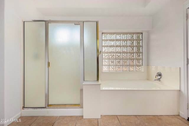 full bathroom featuring tile patterned floors, a garden tub, and a stall shower