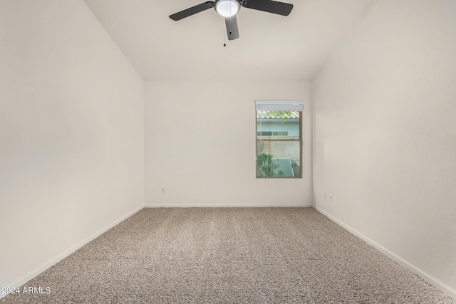 carpeted empty room with baseboards, a ceiling fan, and vaulted ceiling