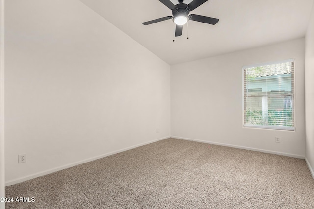 carpeted spare room featuring baseboards, a ceiling fan, and vaulted ceiling