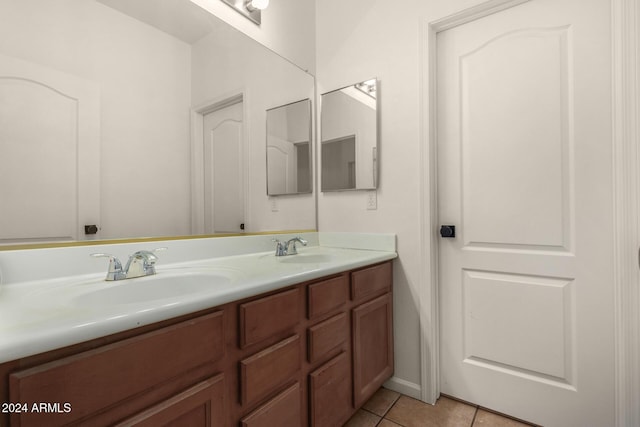 bathroom featuring tile patterned flooring, double vanity, and a sink