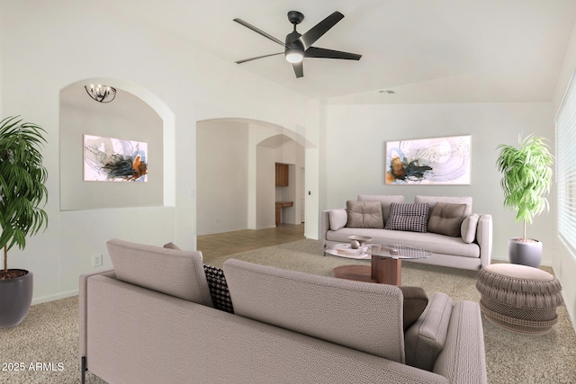 living area with arched walkways and ceiling fan with notable chandelier