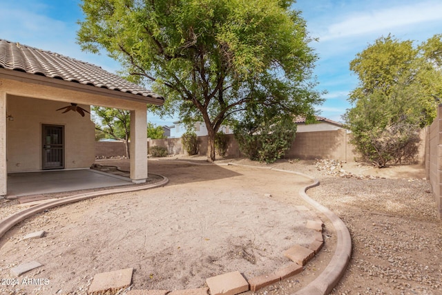 view of yard featuring a patio area, a ceiling fan, and a fenced backyard