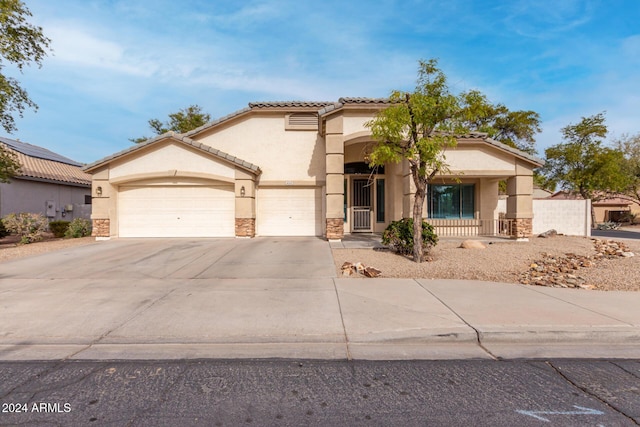 mediterranean / spanish home with stucco siding, stone siding, concrete driveway, and an attached garage