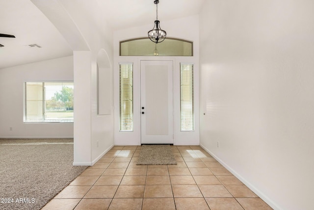 foyer with light tile patterned floors, lofted ceiling, and plenty of natural light