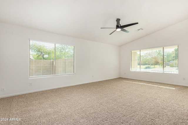 empty room with light carpet, visible vents, a healthy amount of sunlight, and vaulted ceiling