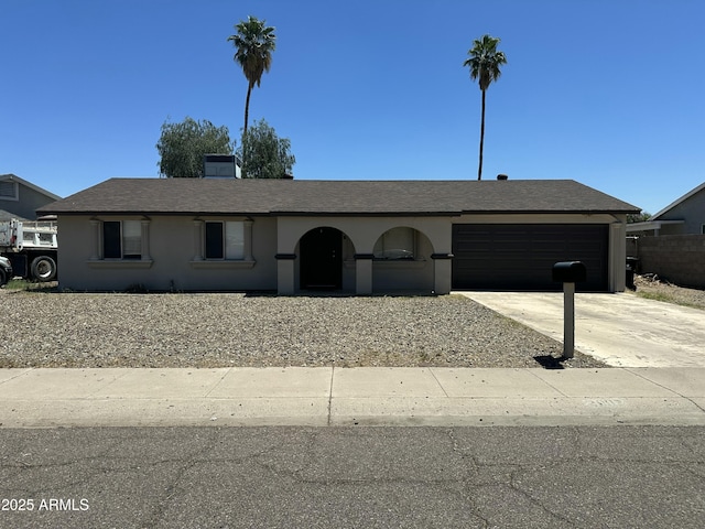 ranch-style house featuring an attached garage, concrete driveway, and stucco siding