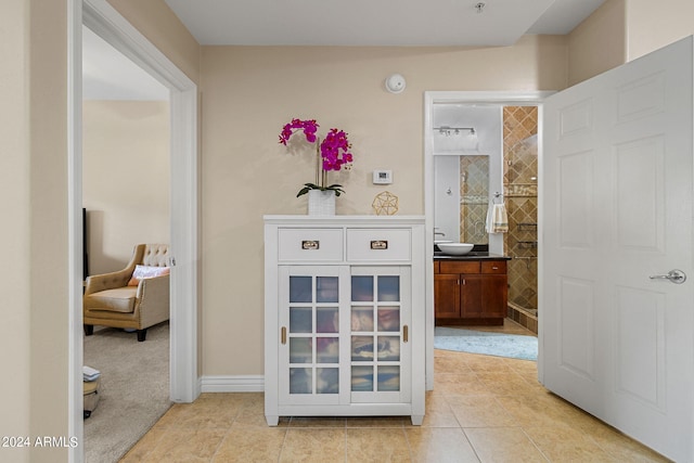 bathroom featuring tile patterned flooring, tiled shower, and vanity