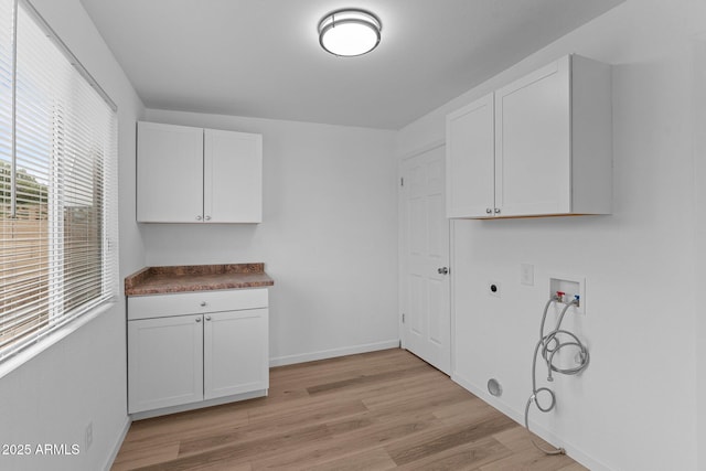 laundry area featuring cabinets, washer hookup, hookup for an electric dryer, light hardwood / wood-style flooring, and gas dryer hookup