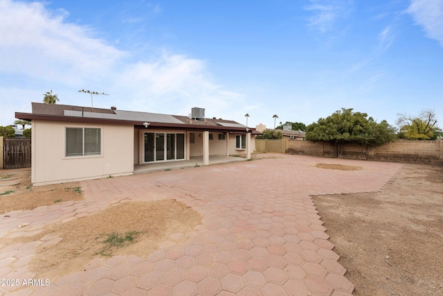 back of house featuring solar panels, central AC, and a patio area