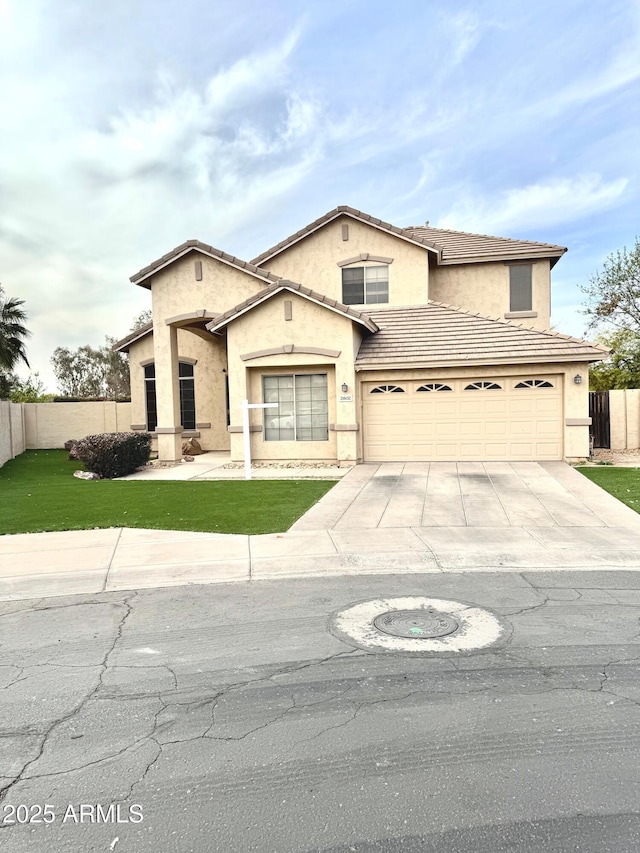 view of front facade with driveway, a front yard, fence, and stucco siding