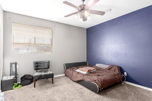 carpeted bedroom featuring baseboards, a ceiling fan, and a textured wall