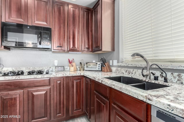 kitchen with black microwave, dishwashing machine, gas cooktop, a sink, and dark brown cabinets