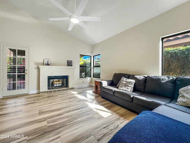 living room featuring baseboards, vaulted ceiling, wood finished floors, and a high end fireplace