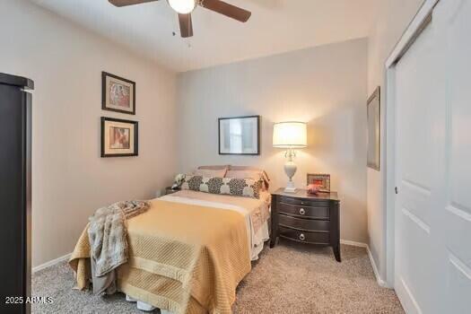 carpeted bedroom with ceiling fan and a closet