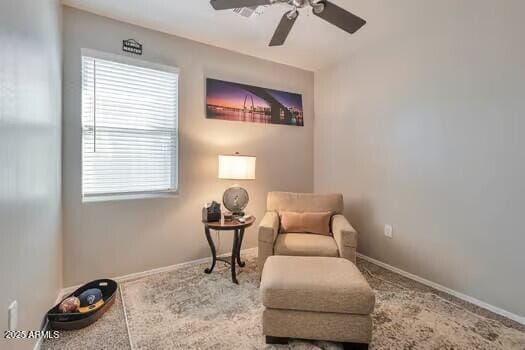 living area with carpet flooring, ceiling fan, and a healthy amount of sunlight